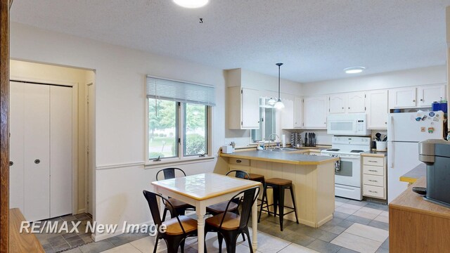 3257 N Christy Way, Saginaw, MI 48603 - kitchen with white appliances, a sink, a peninsula, white cabinetry, and pendant lighting