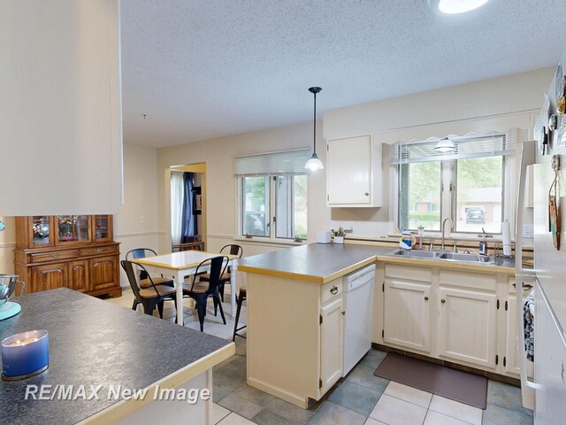 3257 N Christy Way, Saginaw, MI 48603 - kitchen featuring dishwasher, a sink, white cabinetry, a peninsula, and a textured ceiling