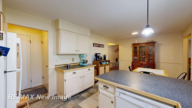 3257 N Christy Way, Saginaw, MI 48603 - kitchen with white appliances, dark countertops, white cabinets, and hanging light fixtures