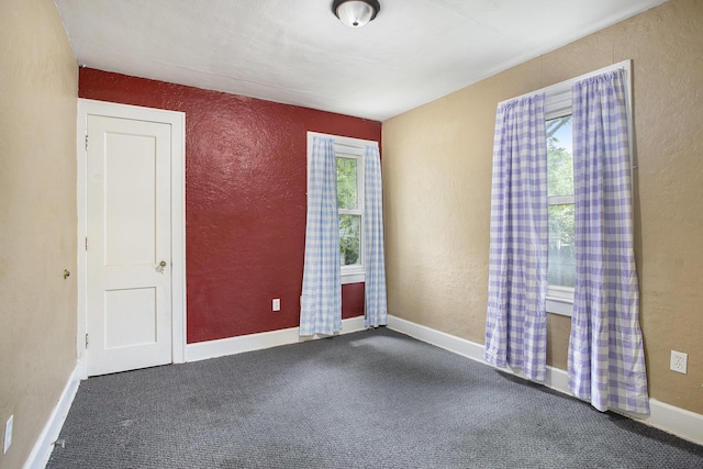 1767 W Michigan Ave, Battle Creek, MI 49037 - spare room featuring a textured wall, dark carpet, and baseboards