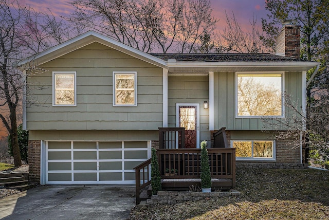 2149 Fair St, Ann Arbor, MI 48103 - bi-level home with a chimney, an attached garage, concrete driveway, and board and batten siding