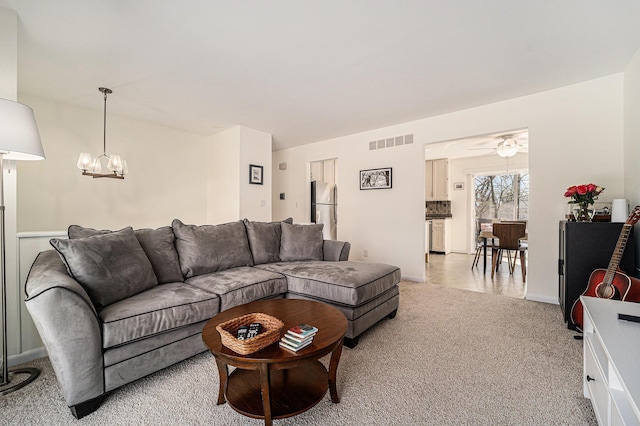 2149 Fair St, Ann Arbor, MI 48103 - living room with a chandelier, light carpet, ceiling fan, and baseboards