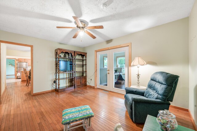 20550 19 Mile Rd, Big Rapids, MI 49307 - sitting room with french doors, baseboards, light wood-style floors, a textured ceiling, and a ceiling fan