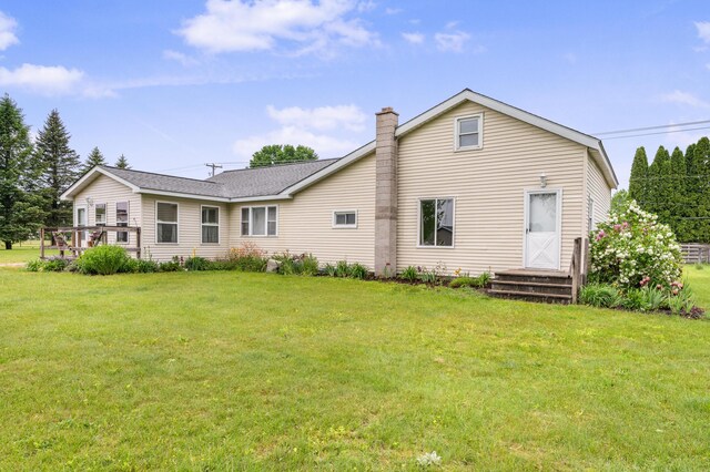 20550 19 Mile Rd, Big Rapids, MI 49307 - rear view of house with a chimney and a lawn