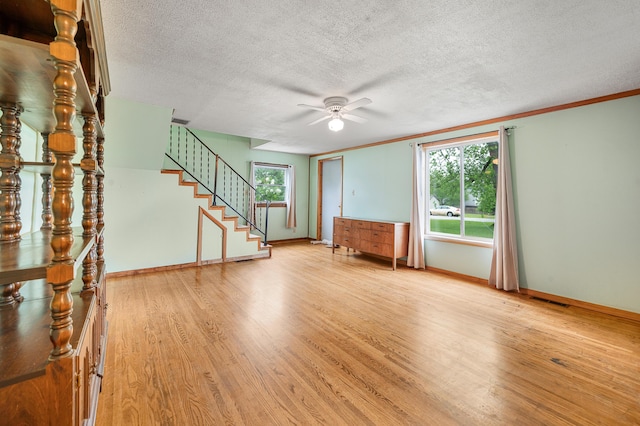 20550 19 Mile Rd, Big Rapids, MI 49307 - unfurnished living room featuring light wood-style flooring, a ceiling fan, plenty of natural light, stairway, and a textured ceiling