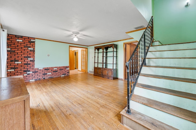 20550 19 Mile Rd, Big Rapids, MI 49307 - unfurnished living room with a ceiling fan, stairway, wood finished floors, crown molding, and brick wall