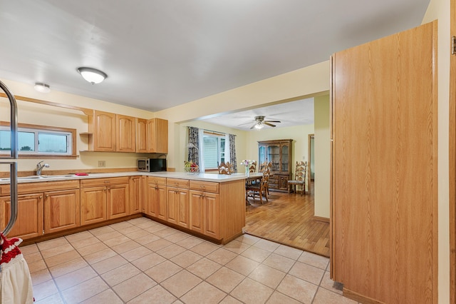20550 19 Mile Rd, Big Rapids, MI 49307 - kitchen featuring stainless steel microwave, light countertops, a peninsula, light tile patterned floors, and a sink