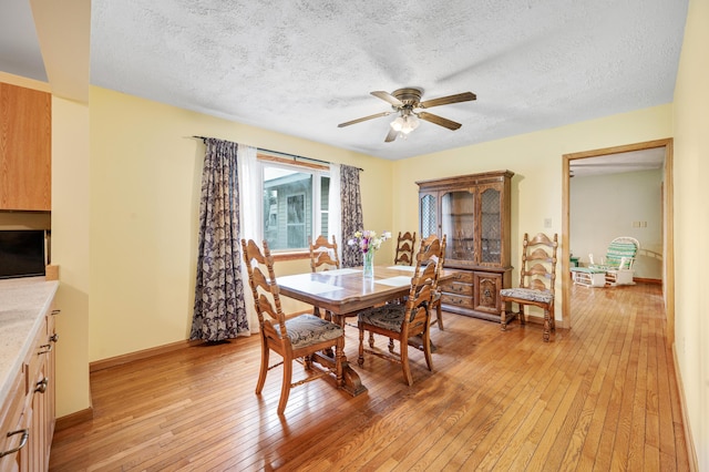 20550 19 Mile Rd, Big Rapids, MI 49307 - dining space with light wood finished floors, a textured ceiling, a ceiling fan, and baseboards