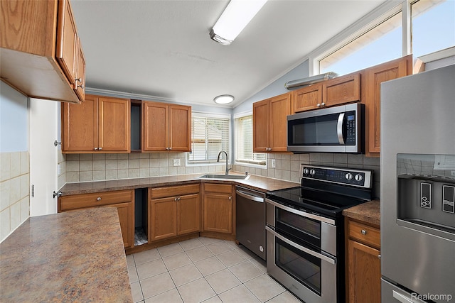 5115 Arden Ave, Warren, MI 48092 - kitchen featuring stainless steel appliances, a sink, vaulted ceiling, brown cabinetry, and decorative backsplash