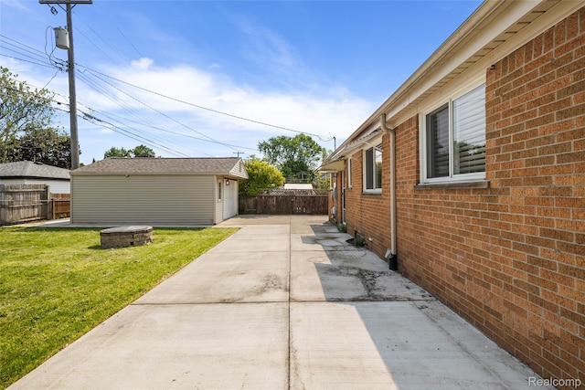 5115 Arden Ave, Warren, MI 48092 - view of side of property featuring a patio area, brick siding, and an outbuilding
