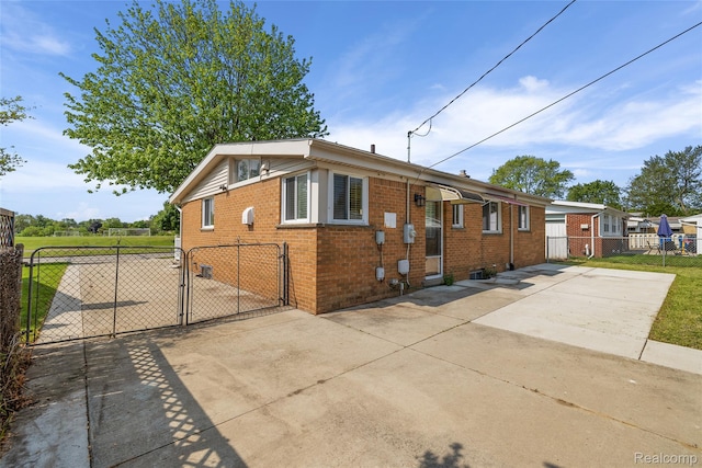 5115 Arden Ave, Warren, MI 48092 - bungalow-style home with a gate, concrete driveway, and brick siding