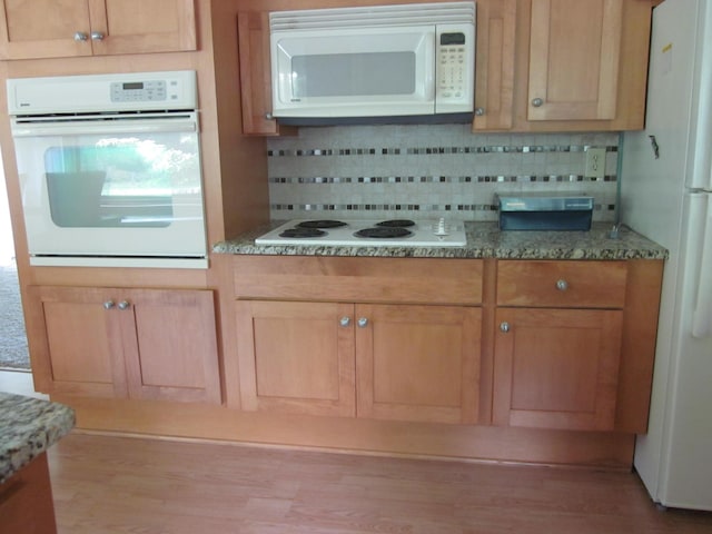 43859 60th Ave, Paw Paw, MI 49079 - kitchen with white appliances, decorative backsplash, wood finished floors, and light stone counters