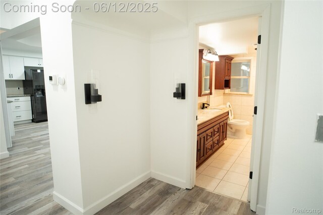 626 Wilwood Rd, Rochester Hills, MI 48309 - hallway featuring light wood-type flooring, baseboards, and a sink