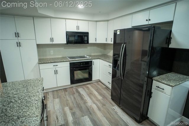 626 Wilwood Rd, Rochester Hills, MI 48309 - kitchen featuring black appliances, light wood-style flooring, white cabinetry, light stone counters, and backsplash