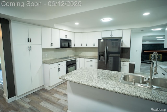 626 Wilwood Rd, Rochester Hills, MI 48309 - kitchen featuring black appliances, light wood-style floors, a sink, white cabinetry, and decorative backsplash
