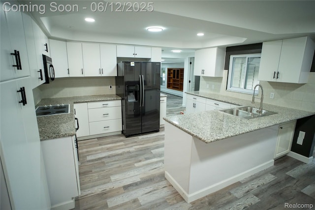 626 Wilwood Rd, Rochester Hills, MI 48309 - kitchen featuring black appliances, a sink, light wood-type flooring, a peninsula, and light stone counters