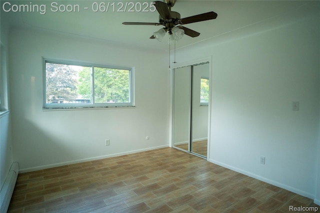 626 Wilwood Rd, Rochester Hills, MI 48309 - unfurnished bedroom with baseboard heating, a closet, baseboards, wood finished floors, and a ceiling fan