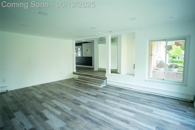 626 Wilwood Rd, Rochester Hills, MI 48309 - unfurnished living room featuring baseboard heating and wood finished floors
