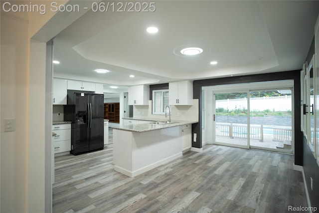 626 Wilwood Rd, Rochester Hills, MI 48309 - kitchen with black fridge with ice dispenser, a sink, a peninsula, white cabinets, and light wood-type flooring