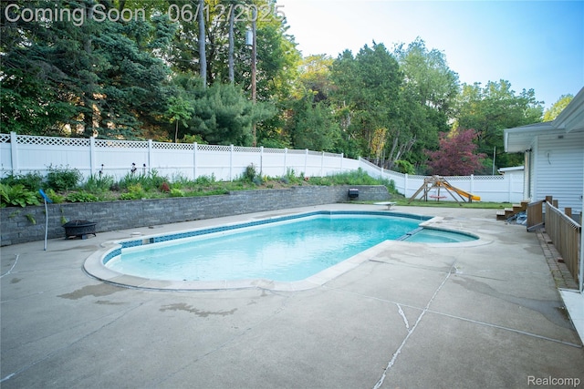 626 Wilwood Rd, Rochester Hills, MI 48309 - view of pool featuring a patio area, a fenced backyard, a diving board, and view of wooded area