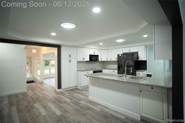 626 Wilwood Rd, Rochester Hills, MI 48309 - kitchen with black appliances, a peninsula, white cabinets, a sink, and recessed lighting