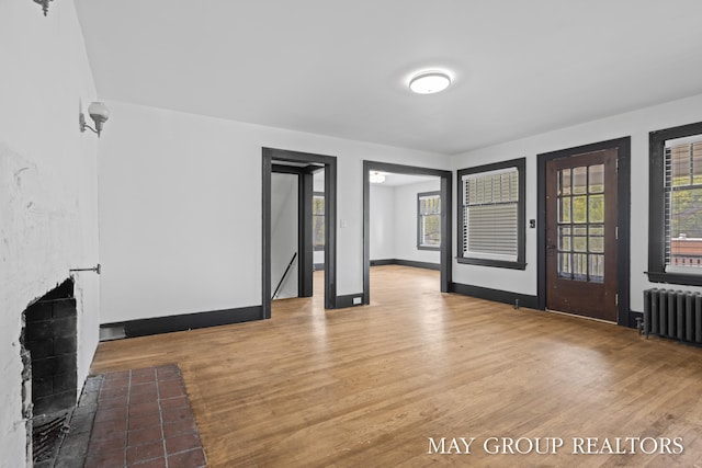 1951 Leonard St NW, Grand Rapids, MI 49504 - unfurnished living room featuring radiator heating unit, wood finished floors, and baseboards