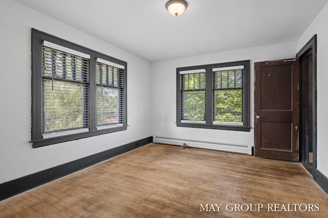 1951 Leonard St NW, Grand Rapids, MI 49504 - unfurnished room featuring a baseboard heating unit, baseboards, and wood finished floors