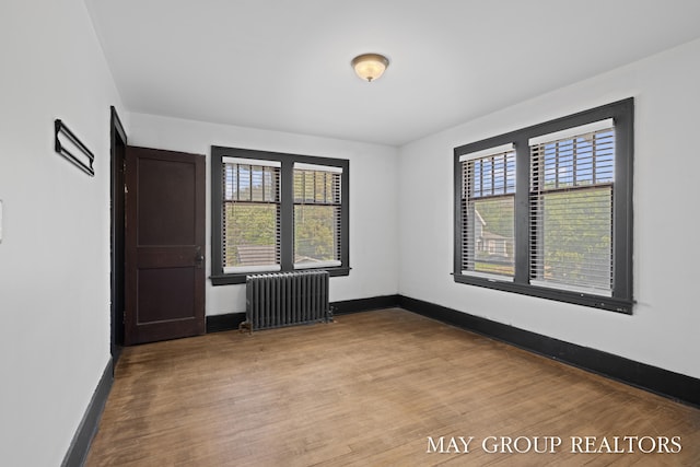 1951 Leonard St NW, Grand Rapids, MI 49504 - unfurnished room with radiator heating unit, wood finished floors, and baseboards