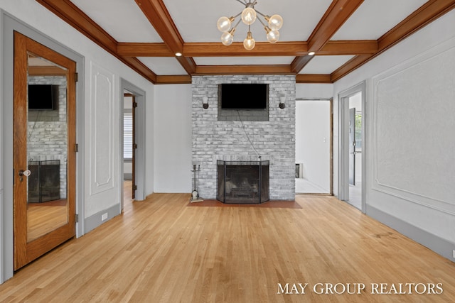 1951 Leonard St NW, Grand Rapids, MI 49504 - unfurnished living room featuring a fireplace, wood finished floors, a chandelier, beam ceiling, and coffered ceiling