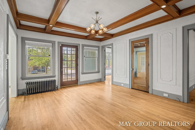 1951 Leonard St NW, Grand Rapids, MI 49504 - spare room featuring radiator, coffered ceiling, wood finished floors, a chandelier, and beamed ceiling