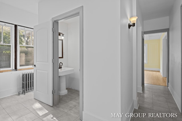 1951 Leonard St NW, Grand Rapids, MI 49504 - hall featuring radiator, light tile patterned floors, and baseboards