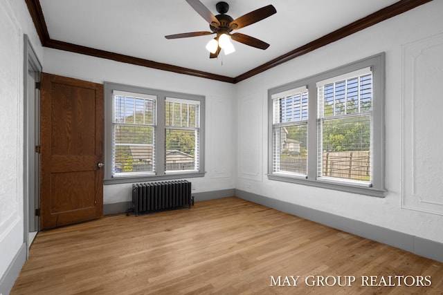 1951 Leonard St NW, Grand Rapids, MI 49504 - empty room featuring radiator heating unit, healthy amount of natural light, crown molding, light wood-style floors, and a ceiling fan
