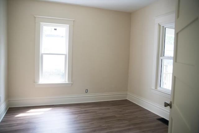 634 Ada St, Kalamazoo, MI 49007 - empty room with healthy amount of natural light, dark wood-style flooring, and baseboards