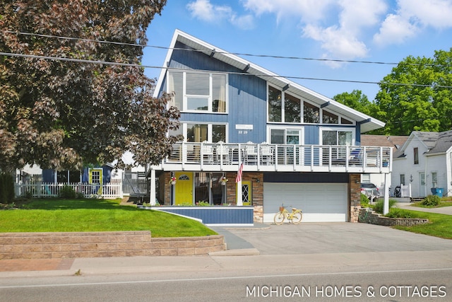 2259 Ottawa Beach Rd, Holland, MI 49424 - view of front of house with driveway, an attached garage, a balcony, and stone siding