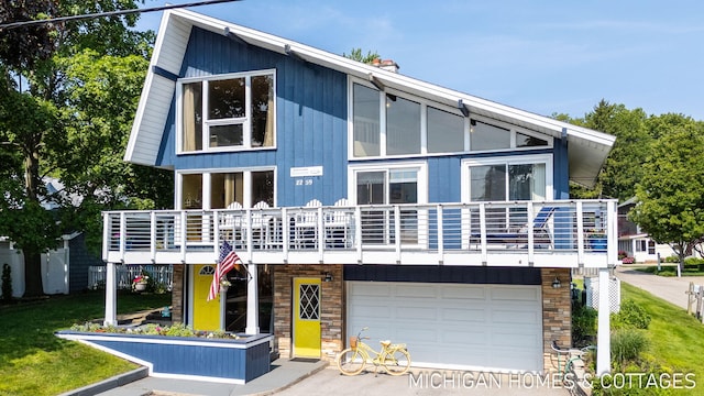 2259 Ottawa Beach Rd, Holland, MI 49424 - view of front facade featuring a garage, stone siding, and concrete driveway