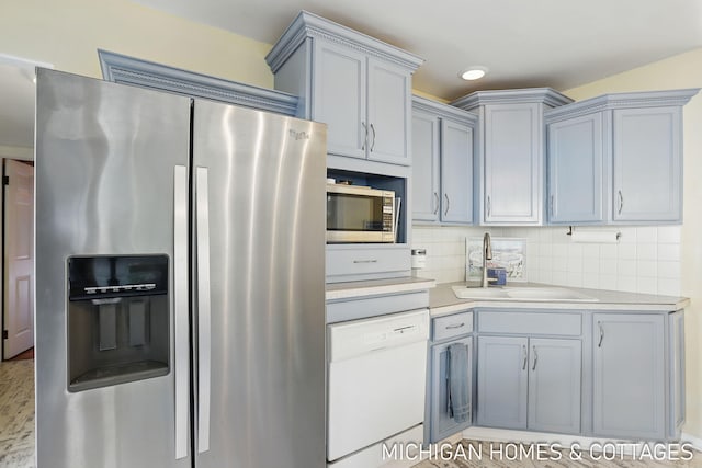 2259 Ottawa Beach Rd, Holland, MI 49424 - kitchen featuring appliances with stainless steel finishes, a sink, light countertops, decorative backsplash, and gray cabinetry