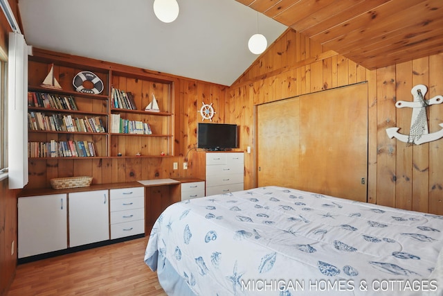 2259 Ottawa Beach Rd, Holland, MI 49424 - bedroom with vaulted ceiling, wood walls, and light wood-style flooring