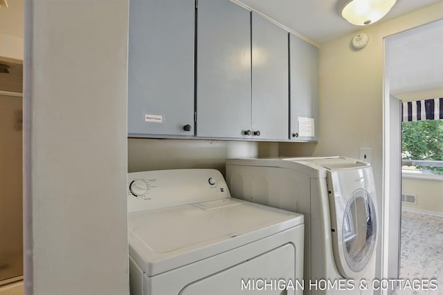 2259 Ottawa Beach Rd, Holland, MI 49424 - laundry area featuring separate washer and dryer, cabinet space, and baseboards