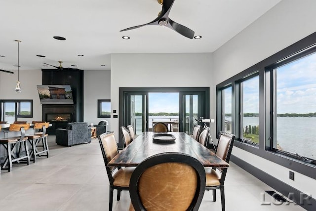 8676 Cherry Point Dr, Manitou Beach, MI 49253 - dining area with a ceiling fan, recessed lighting, a large fireplace, and a water view