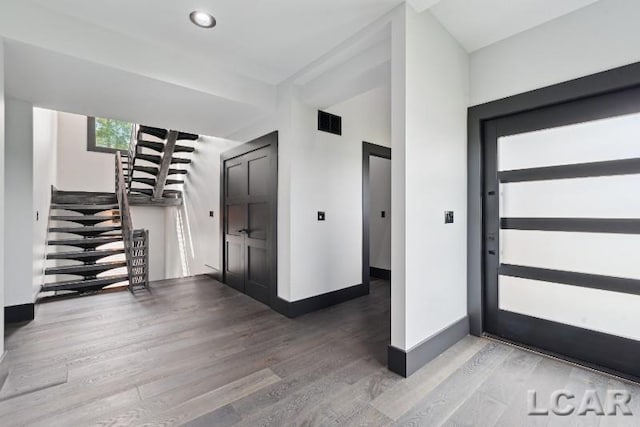 8676 Cherry Point Dr, Manitou Beach, MI 49253 - entrance foyer with wood finished floors, stairs, and baseboards