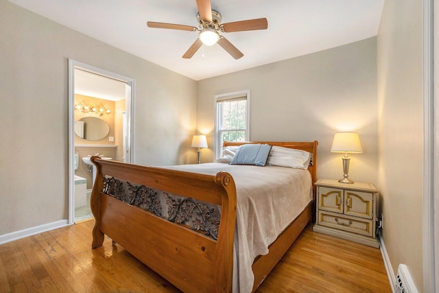 2147 Academy Dr NE, Grand Rapids, MI 49503 - bedroom with light wood-style floors, ensuite bathroom, baseboards, a ceiling fan, and a baseboard heating unit