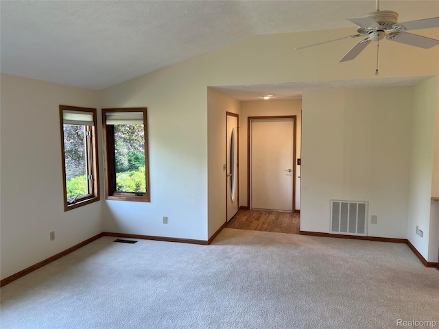 2205 Hammond Place Ctr, Traverse City, MI 49686 - empty room with light carpet, vaulted ceiling, baseboards, and a ceiling fan