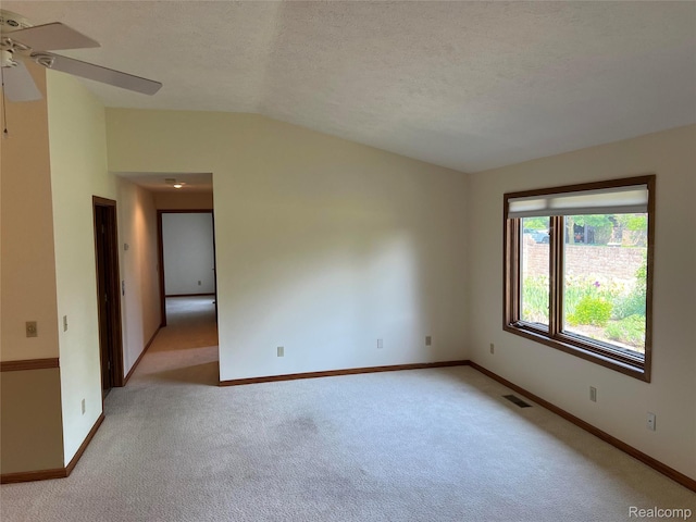 2205 Hammond Place Ctr, Traverse City, MI 49686 - unfurnished room featuring light colored carpet, a ceiling fan, vaulted ceiling, baseboards, and a textured ceiling
