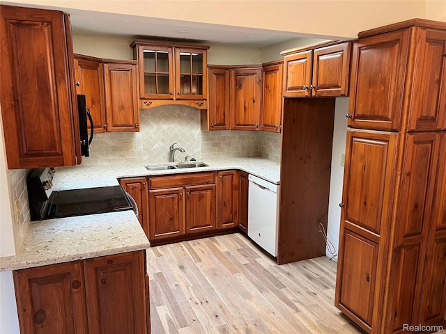2205 Hammond Place Ctr, Traverse City, MI 49686 - kitchen featuring dishwasher, a sink, black / electric stove, light wood-type flooring, and brown cabinetry