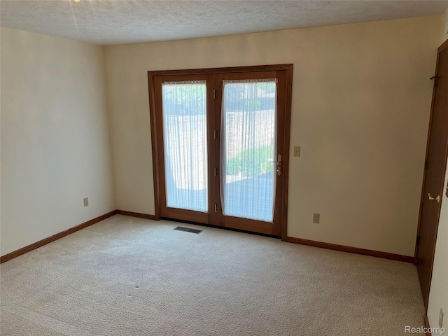 2205 Hammond Place Ctr, Traverse City, MI 49686 - empty room featuring light carpet, a textured ceiling, and baseboards