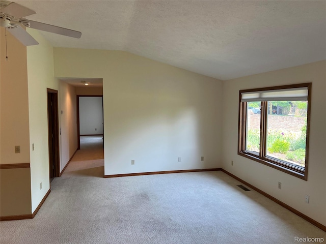 2205 Hammond Place Ctr, Traverse City, MI 49686 - unfurnished room with a ceiling fan, light carpet, vaulted ceiling, baseboards, and a textured ceiling