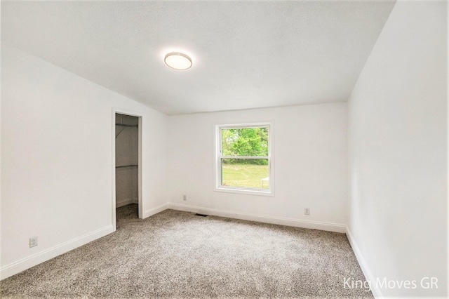 11690 21 Mile Rd NE, Sand Lake, MI 49343 - unfurnished bedroom featuring carpet, baseboards, and a walk in closet