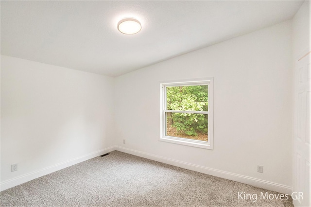11690 21 Mile Rd NE, Sand Lake, MI 49343 - spare room with vaulted ceiling, light colored carpet, and baseboards