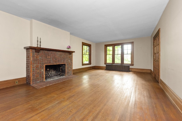 1706 S University Ave, Ann Arbor, MI 48104 - unfurnished living room featuring radiator heating unit, wood-type flooring, and a fireplace