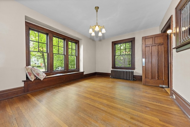 1706 S University Ave, Ann Arbor, MI 48104 - unfurnished room with radiator heating unit, a chandelier, light wood finished floors, and baseboards